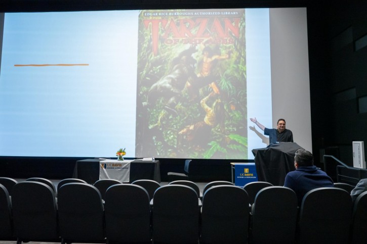 Enrique García stands in front of projector screen addressing the audience.