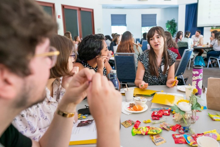 Students sit at a table participating in a group activity