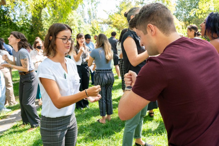 Students stand outside playing Rochambeau/Rock-Paper-Scissors