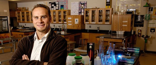 Teacher posing and smiling in science classroom