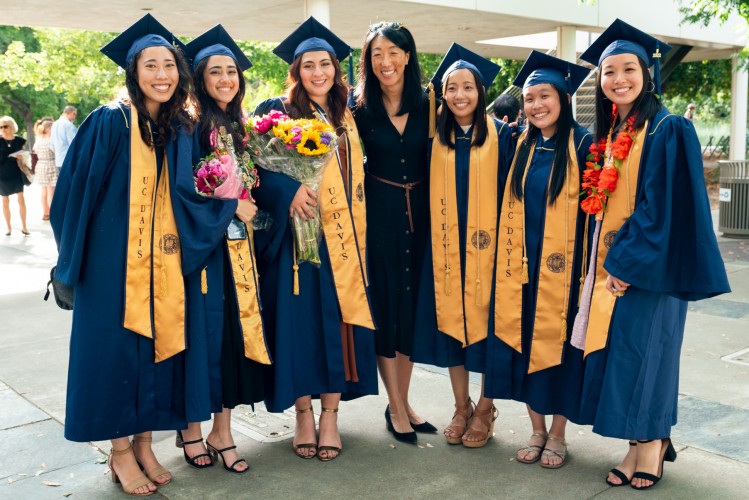 Nancy Tseng with six graduating students in robes