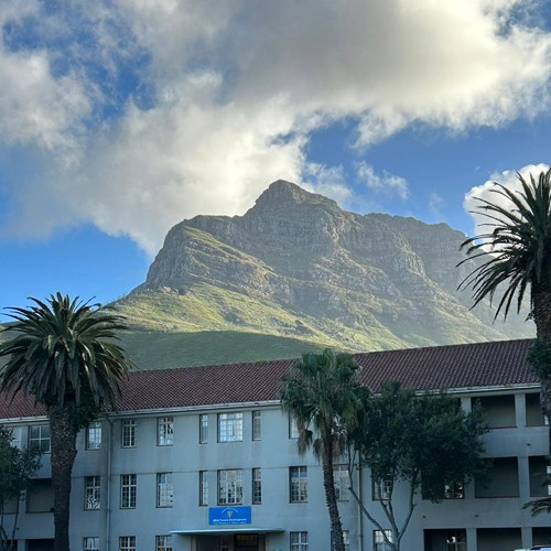 An outside view of the University of Cape Town in front of a mountain.