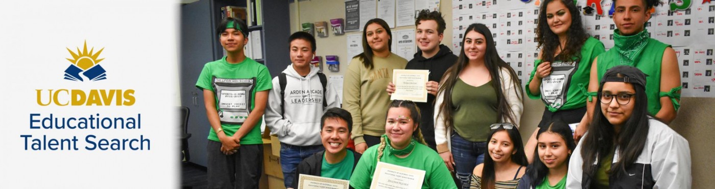 A large group of high school students in a classroom poses with certificates
