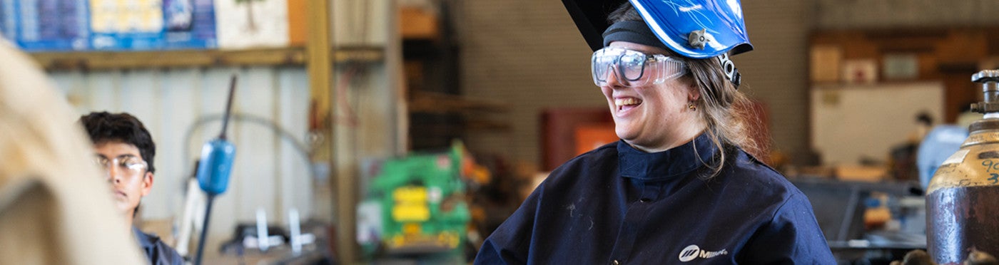 Ag ed credential student in welding gear teaching in high school welding classroom