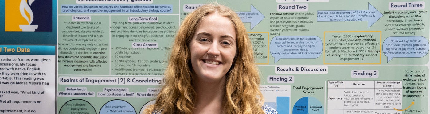 MA student standing in front of their poster
