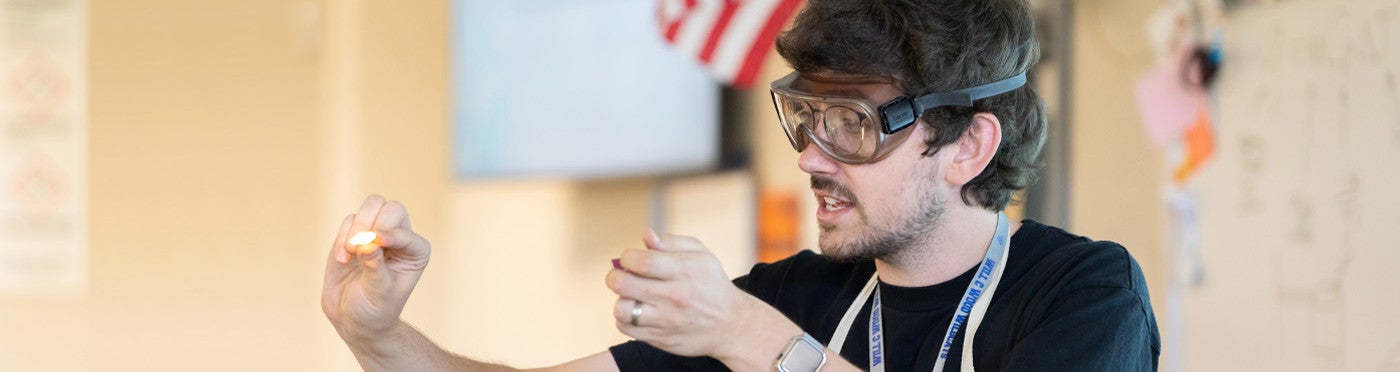 Credential student demonstrating science experiment in high school science class