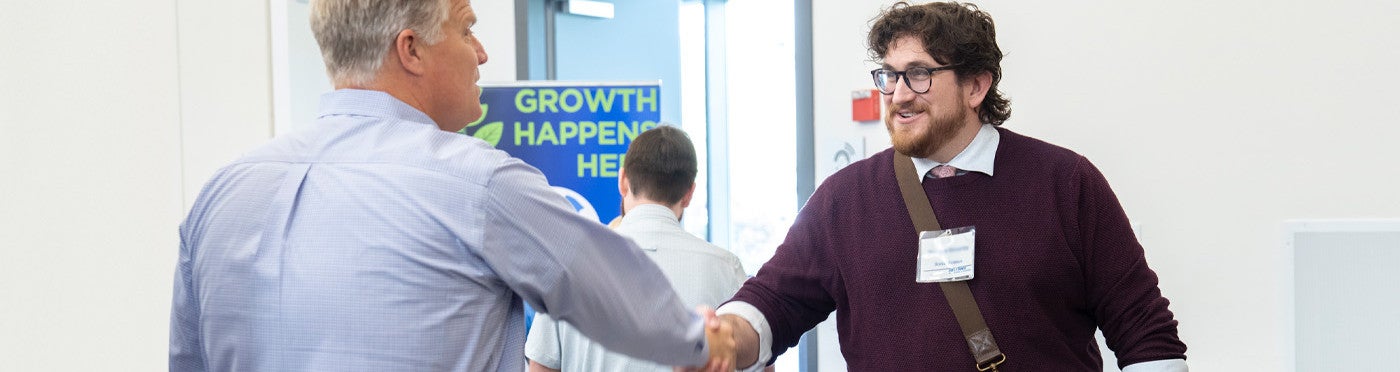 Credential student shakes hands with district recruiter at UC Davis teacher job fair