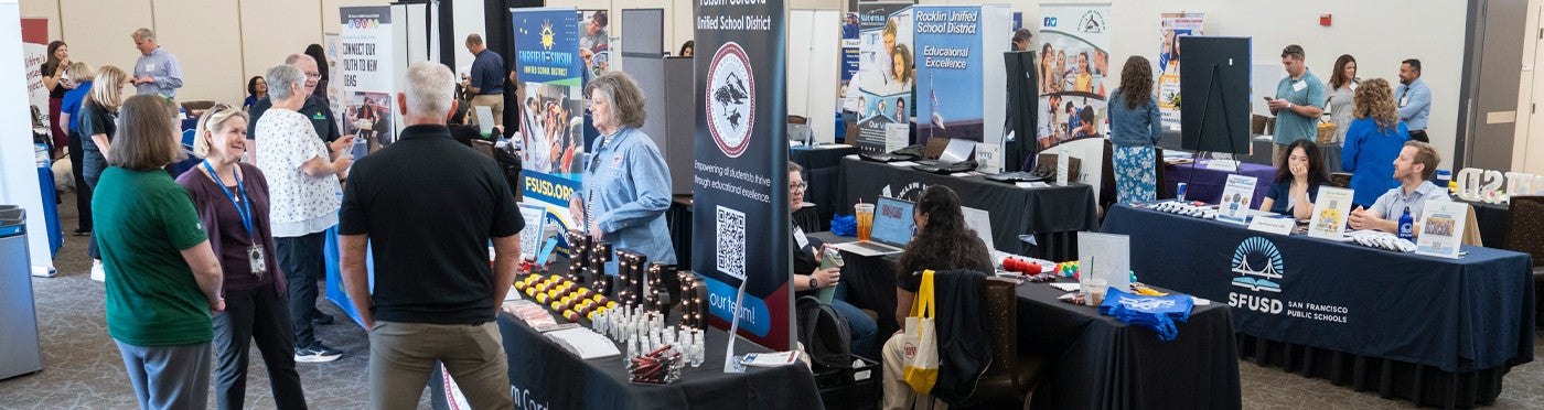 View across the UC DAvis teacher job fair showing booths, district recruiters and job seekers