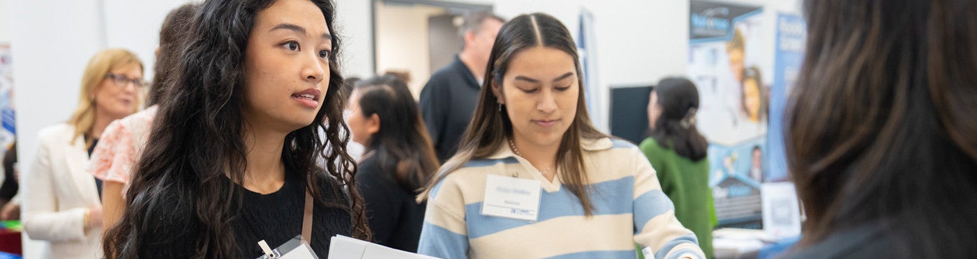Two credential student speaking with district recruiter at UC Davis teacher job fair