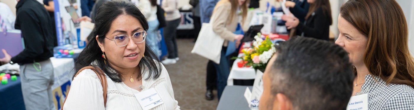 Credential student speaks with district recruiters at UC Davis teacher job fair