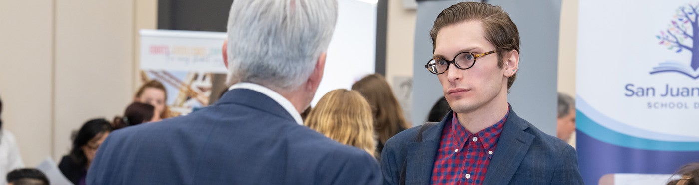 Credential student speaks with district recruiter at UC Davis teacher job fair