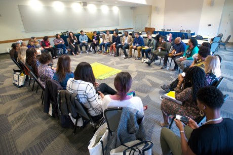 Conference attendees sitting in chairs arranged in a circle