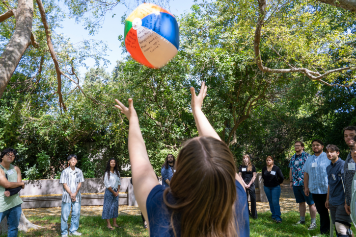 A student reaches up to catch a beach ball