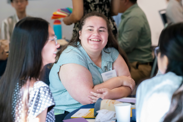 A student smiles at the girl next to her.