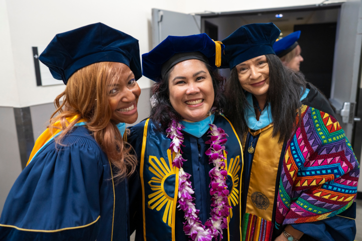 Three EdD grads smile backstage.