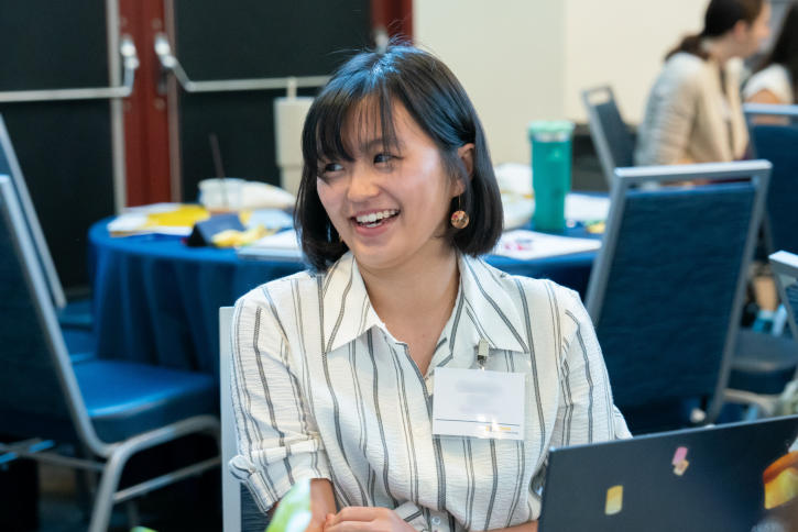 A student with short, dark hair and bangs smiles.