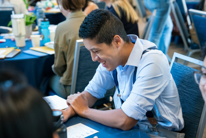 A student smiles while taking notes.