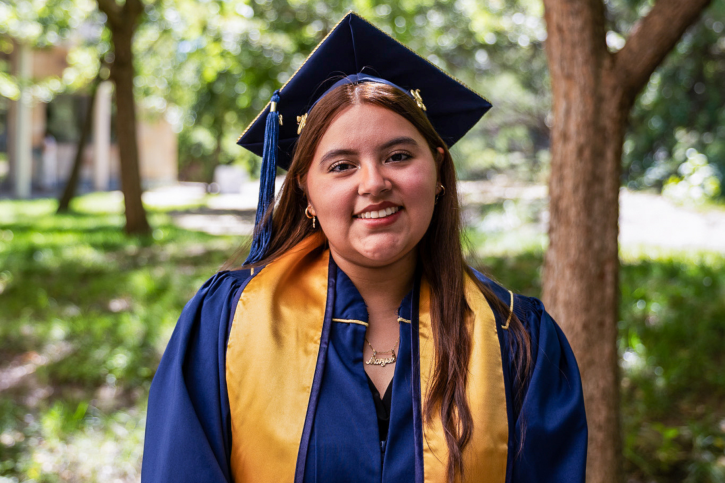 A credential graduate smiles for the camera outside the Mondavi Center.