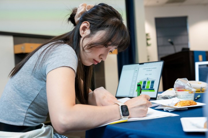 A student with her laptop open takes notes