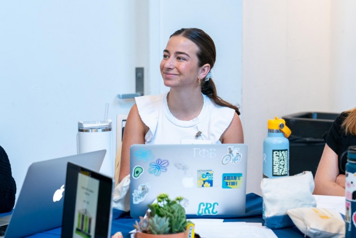 A student smiles, looking off-camera