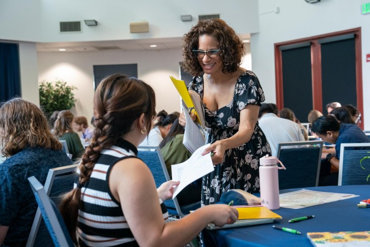 Lola Muldrew collects papers from a student.