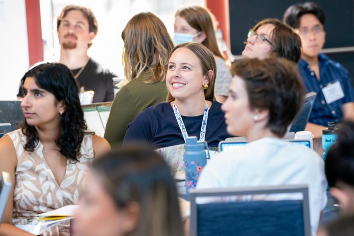 Students listen to the speaker, smiling.