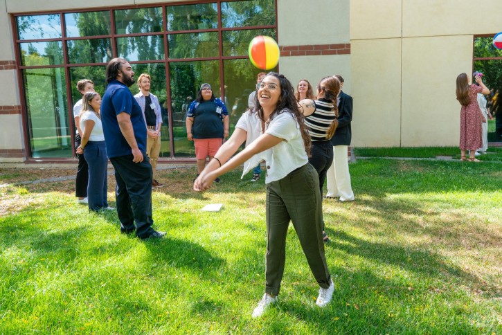 A student puts her hands out to hit a beach ball into the air.