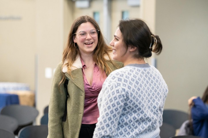 Two women face each other and smile.