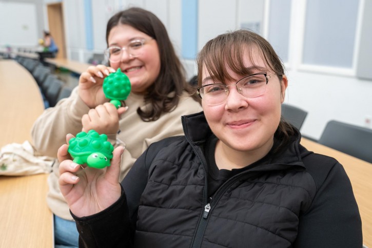 Two students hold up stress balls they've received from the event.