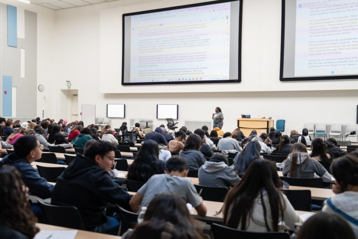 Students fill a lecture hall, working on a letter writing campaign.