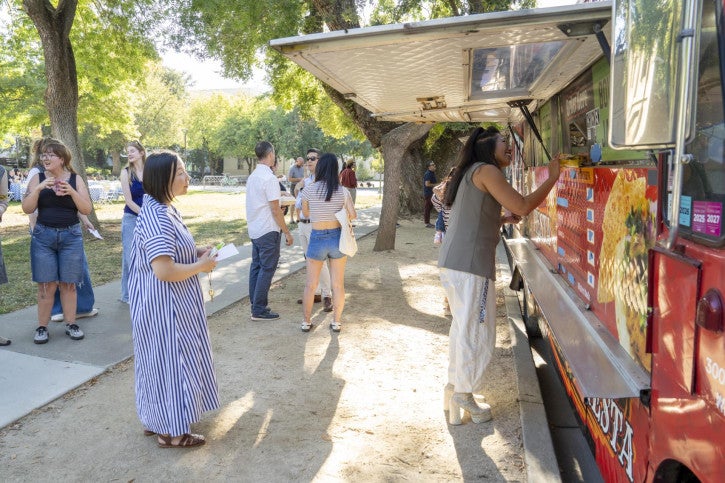 Fall Welcome attendees queue up to order dinner from two food trucks.