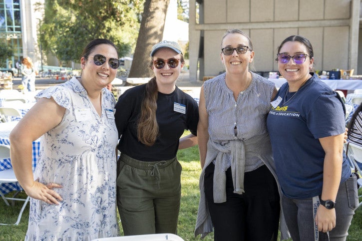 School of Education faculty and staff stand arm in arm and smile.