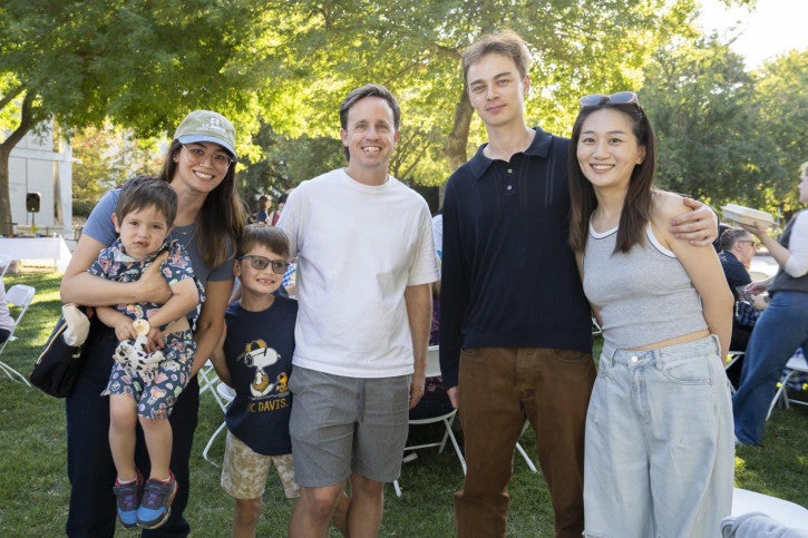 Two PhD students pose for a photo with their families.