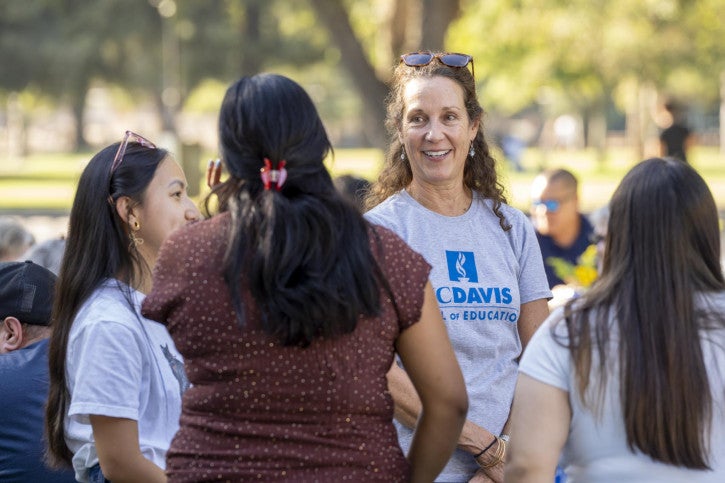 Lisa Sullivan speaks to two credential students.