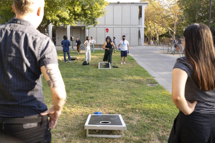 Faculty, staff, and students compete in a corn hole tournament.