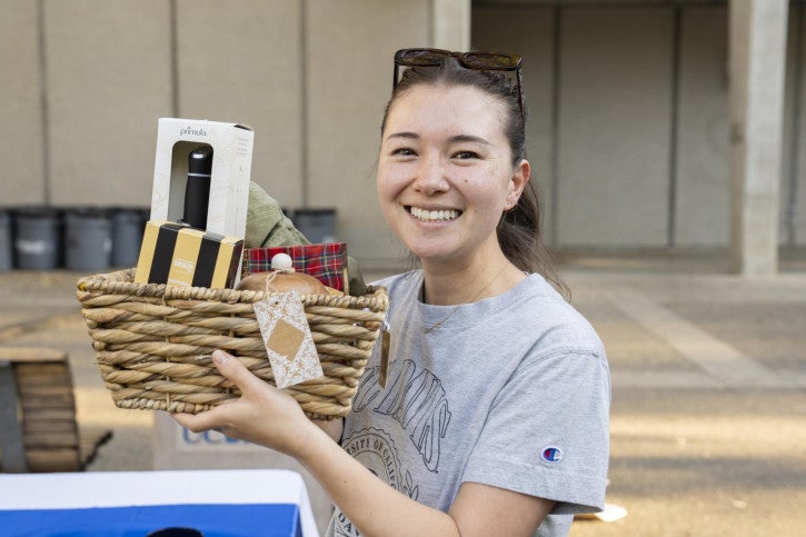 A raffle winner holds up her basket of treats.