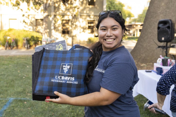 A raffle winner holds up her basket of treats.