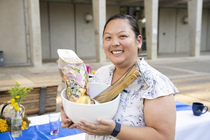 A raffle winner holds up her basket of treats.