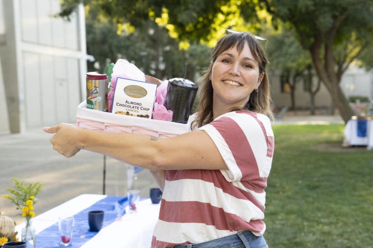 A raffle winner holds up her basket of treats.