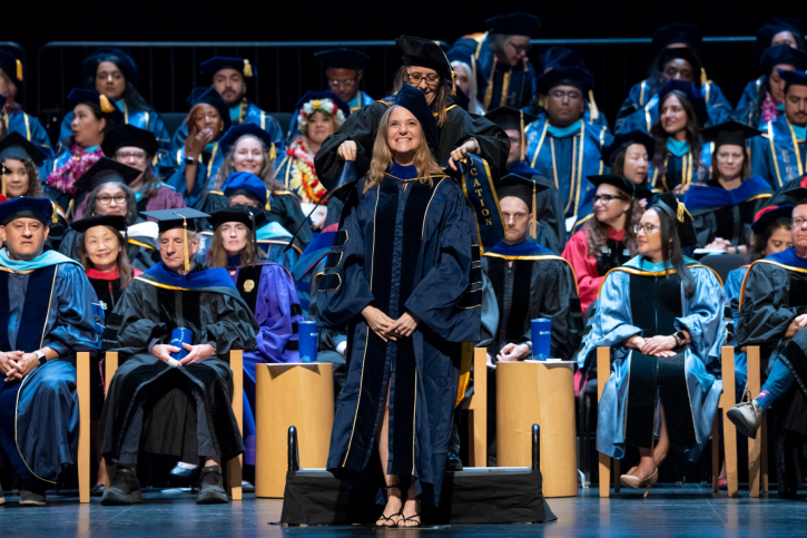 PhD grad Valeria smiles widely as she is given her stole.