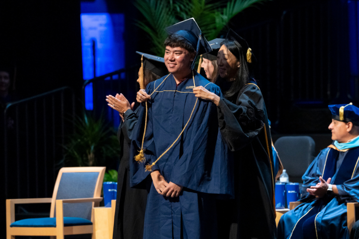 Credential grad Selig recieves his cord.