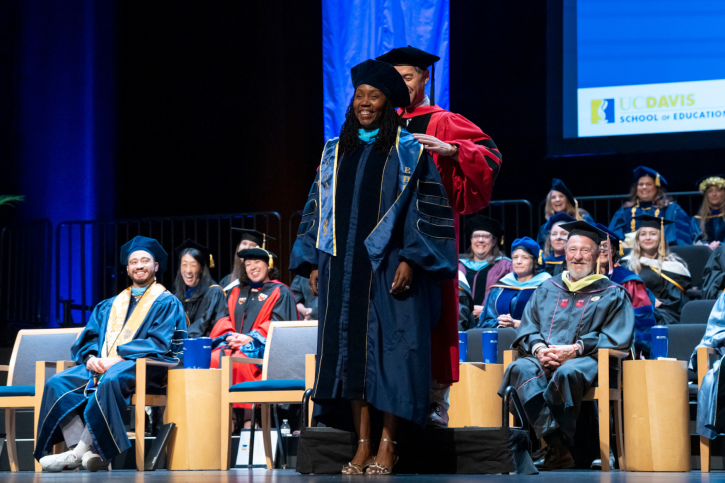 EdD grad Donelle receives her stole, smiling.