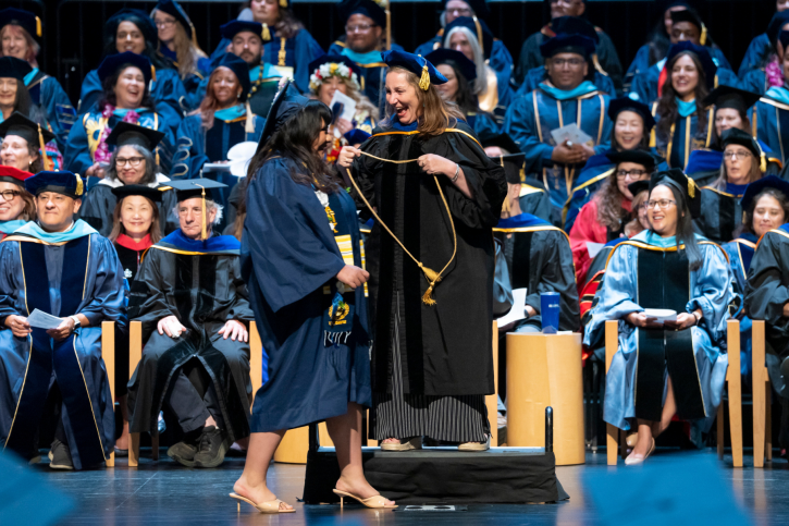 Credential grad Jasmine and supervisor Lynn Martindale smile at each other as Jasmine walks up to receive her cord.