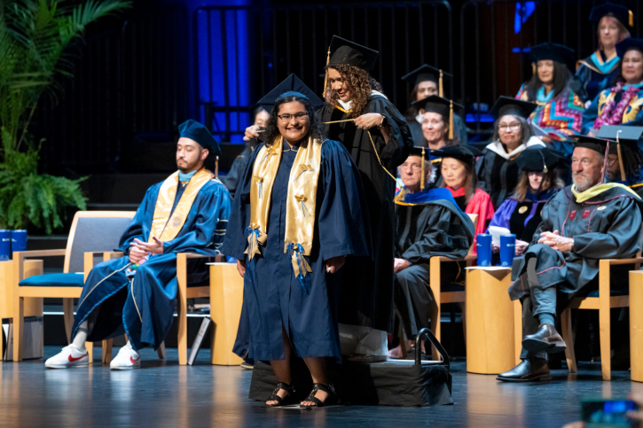 A credential student smiles as she receives her cord.