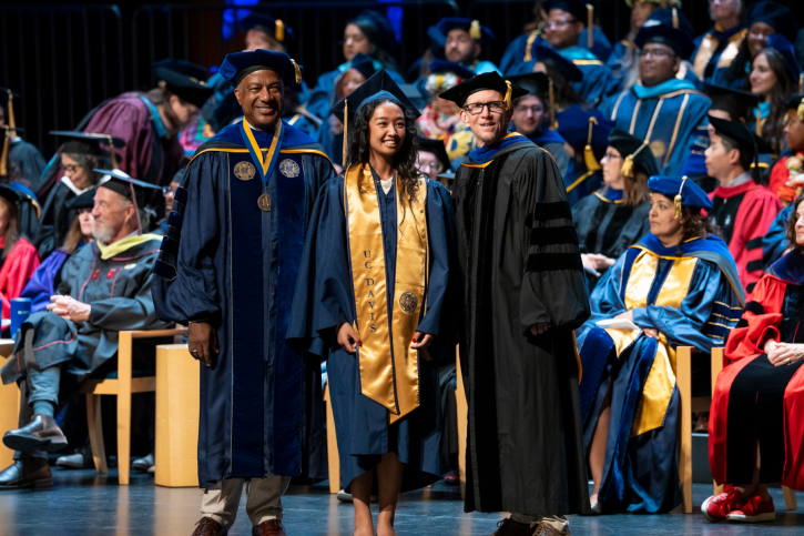 Credential grad Erin smiles with Chancellor May and Dean Smith.