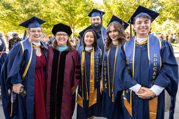 Megan Bettis smiles with a group of science MA grads.