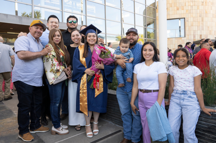 A credential graduate smiles, surrounded by her family.