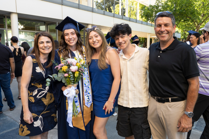 A credential grad smiles with her family.