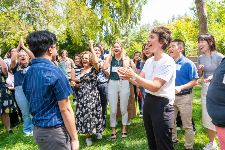 A group cheers as two students play rock paper scissors.