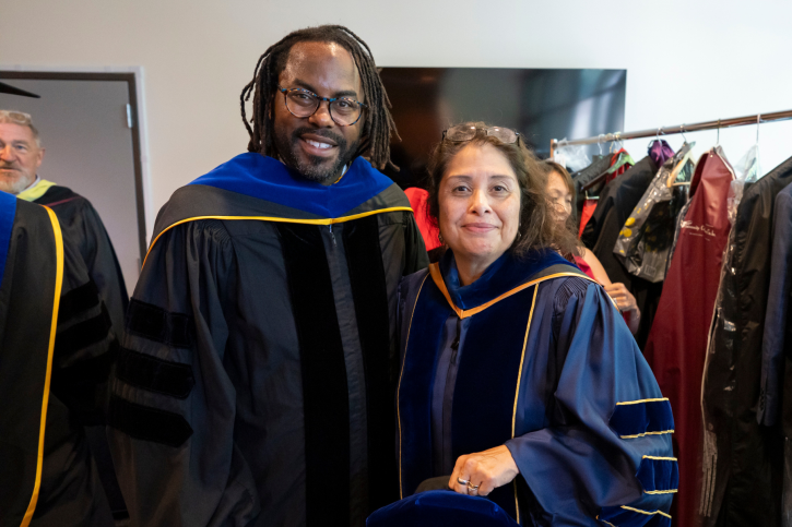 Dr. Torry Winn and Dr. Rosa Rodriguez smile, wearing their regalia.